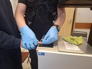 Policjanci wykonują czynności z zatrzymanym mężczyzną.