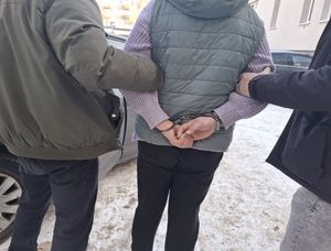 Policjanci prowadzą zatrzymana kobietę.