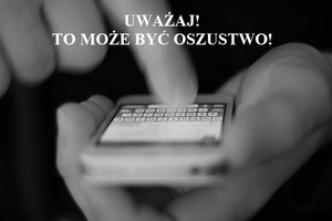 Ręka, telefon, napis :Uważaj. To może być oszustwo.