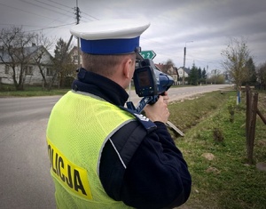 Policjant stoi przy drodze.