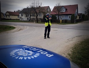 Policjant stoi przy drodze.