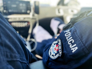 Napis POLICJA na mundurze policjanta.
