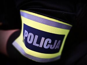 Napis POLICJA na opasce naramiennej.