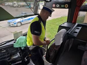 Policjant kontroluje autobus.
