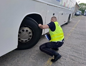 Policjant kontroluje autobus.