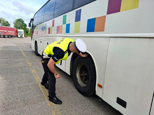 Policjant kontroluje autobus.