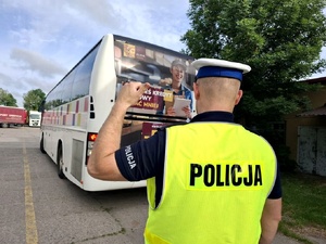 Policjant kontroluje autobus.