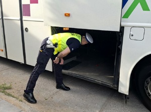 Policjant kontroluje autobus.