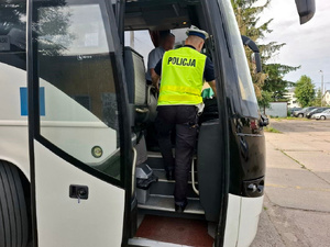 Policjant kontroluje autobus.