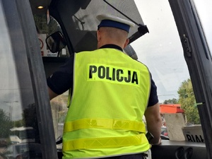 Policjant kontroluje autobus.