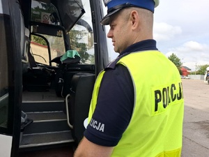 Policjant kontroluje autobus.