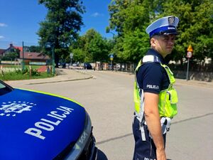 Policjant stoi przy drodze.