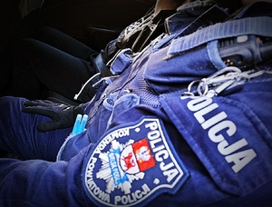 Policjant siedzi w radiowozie.