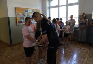 Profilaktycy wręczają nagrody laureatom konkursu plastycznego.