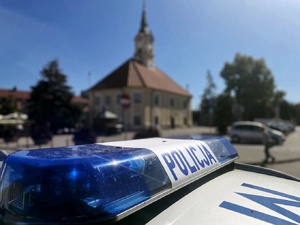 Radiowóz stoi, w tle widać ratusz.