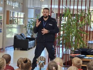 Policjanci uczą dzieci bezpieczeństwa na drodze.