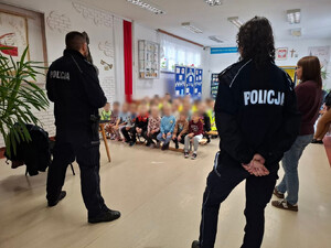 Policjanci uczą dzieci bezpieczeństwa na drodze.