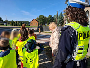Policjanci uczą dzieci bezpieczeństwa na drodze.