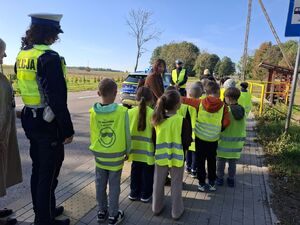 Policjanci uczą dzieci bezpieczeństwa na drodze.