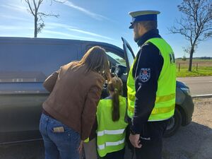 Policjanci uczą dzieci bezpieczeństwa na drodze.