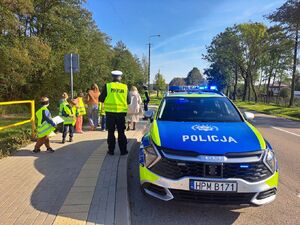 Policjanci uczą dzieci bezpieczeństwa na drodze.